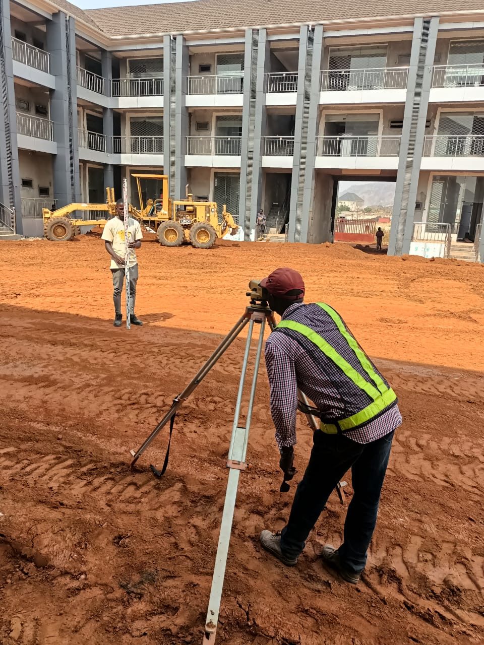 Surveyor taking levels at an institutional building development