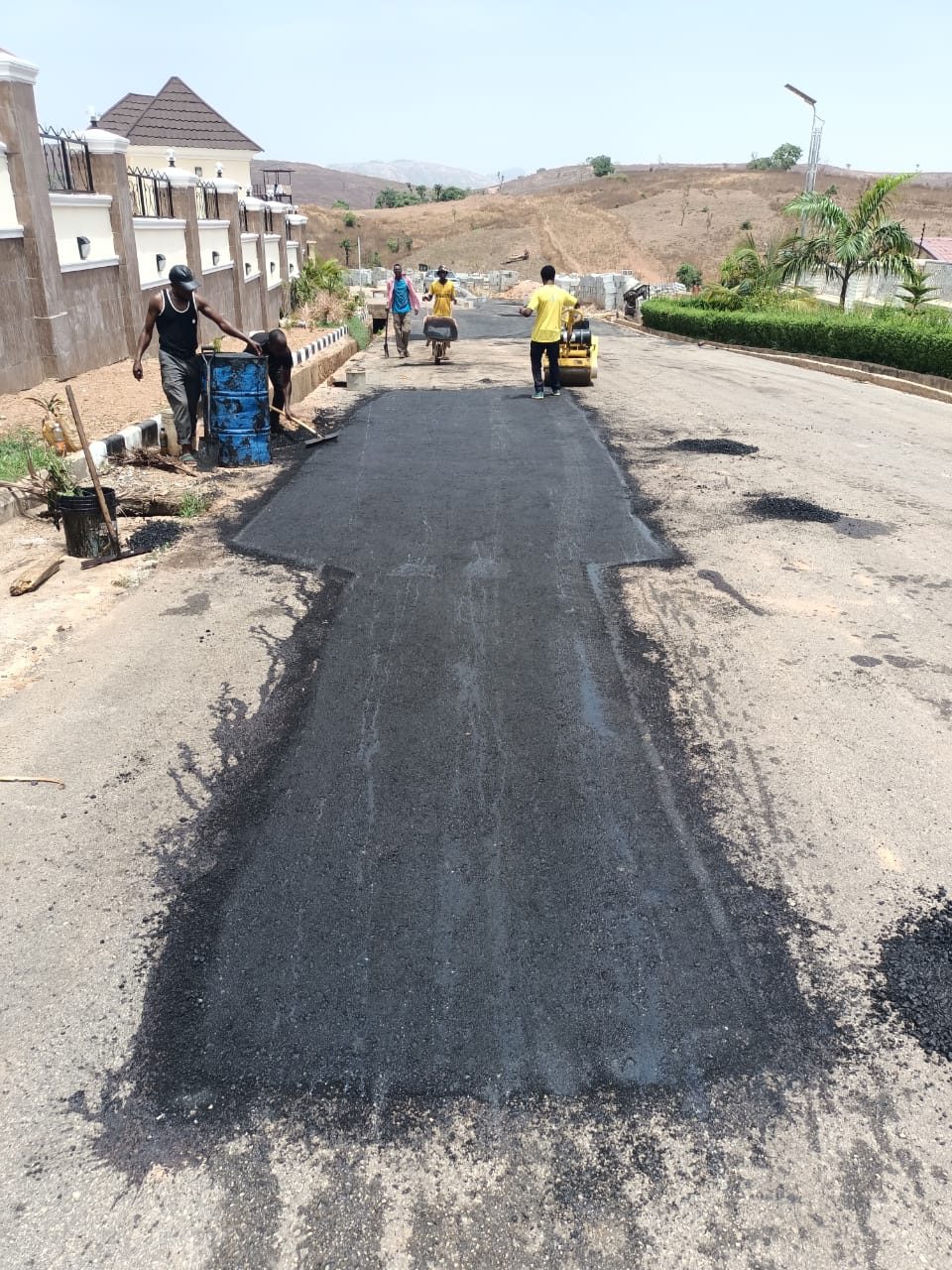 Fresh asphalt overlay along an estate road at NAF Valley Estate, Asokoro