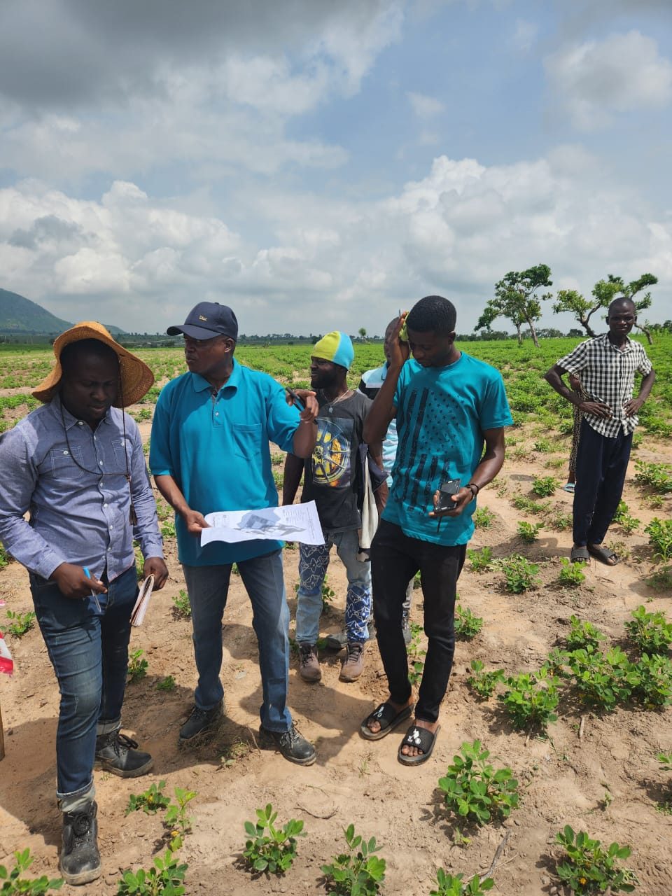 Project team reviewing site drawings during a feasibility inspection, Abuja